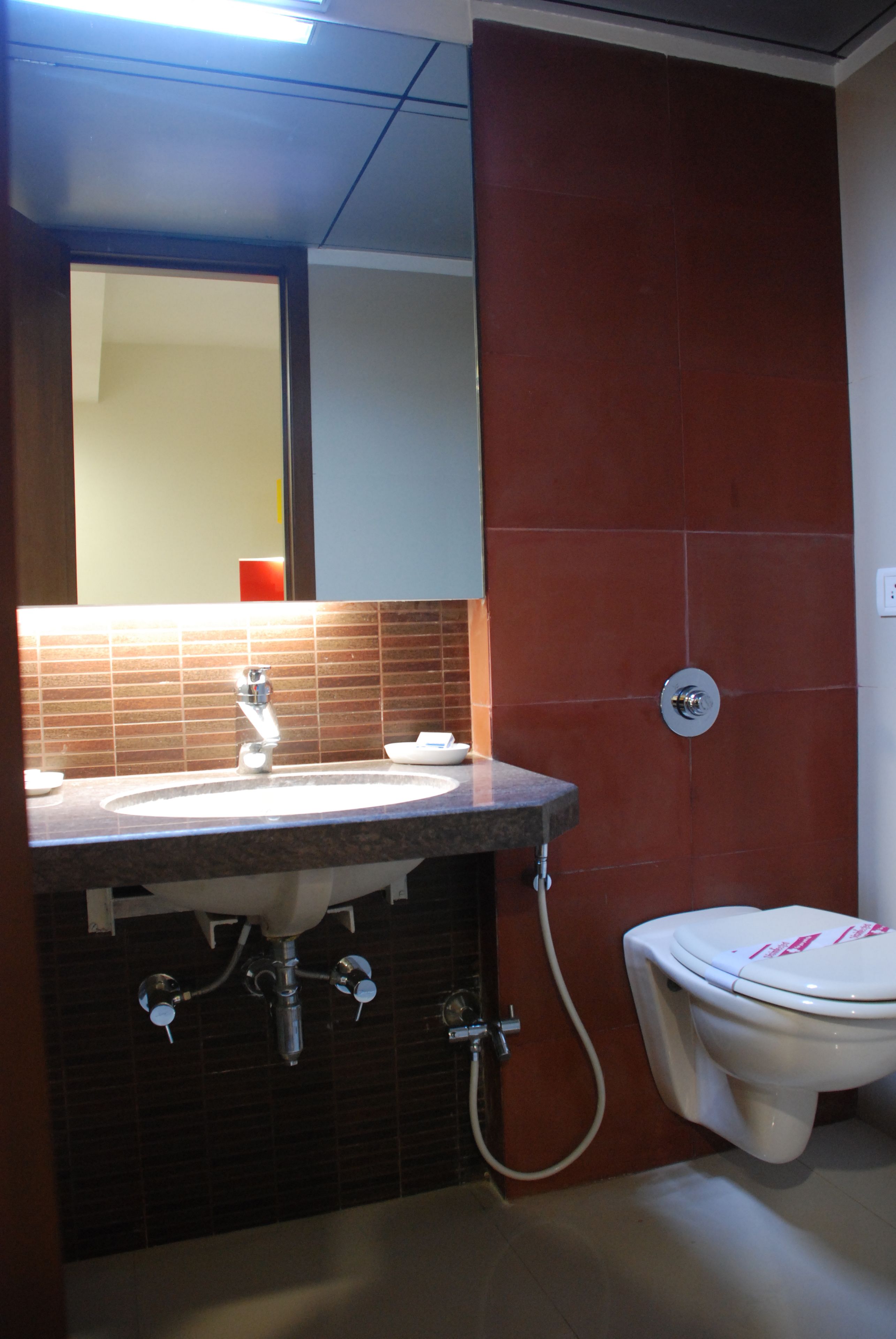 Un baño con lavamanos, espejo y retrete.