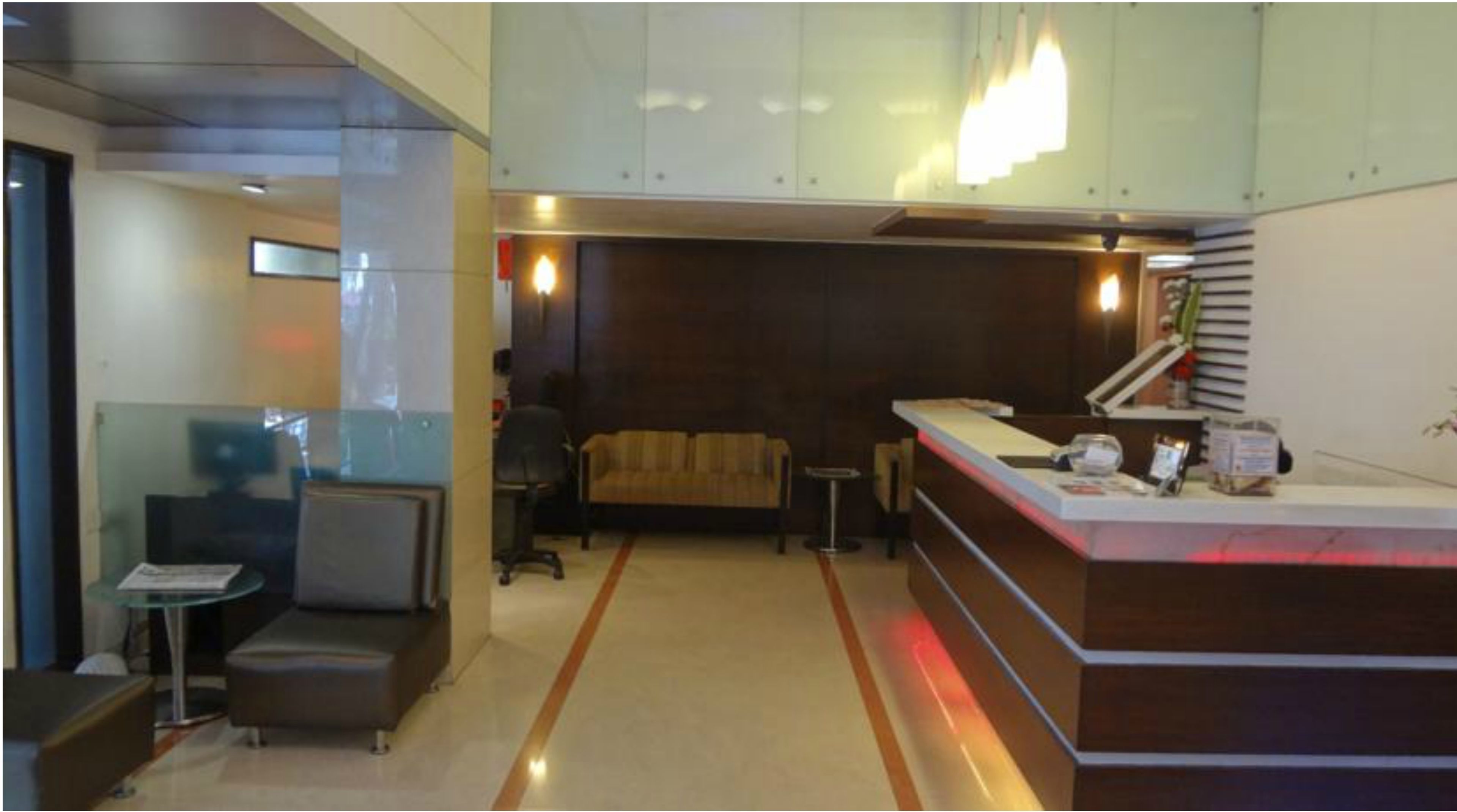 A reception area with a sofa, a small table, and a reception desk.