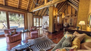 A spacious room with wooden floors, a zebra rug, and a couch with patterned cushions.