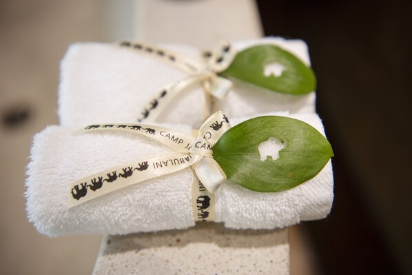 A neatly folded white towel tied with a ribbon and a leaf, with text on the ribbon.