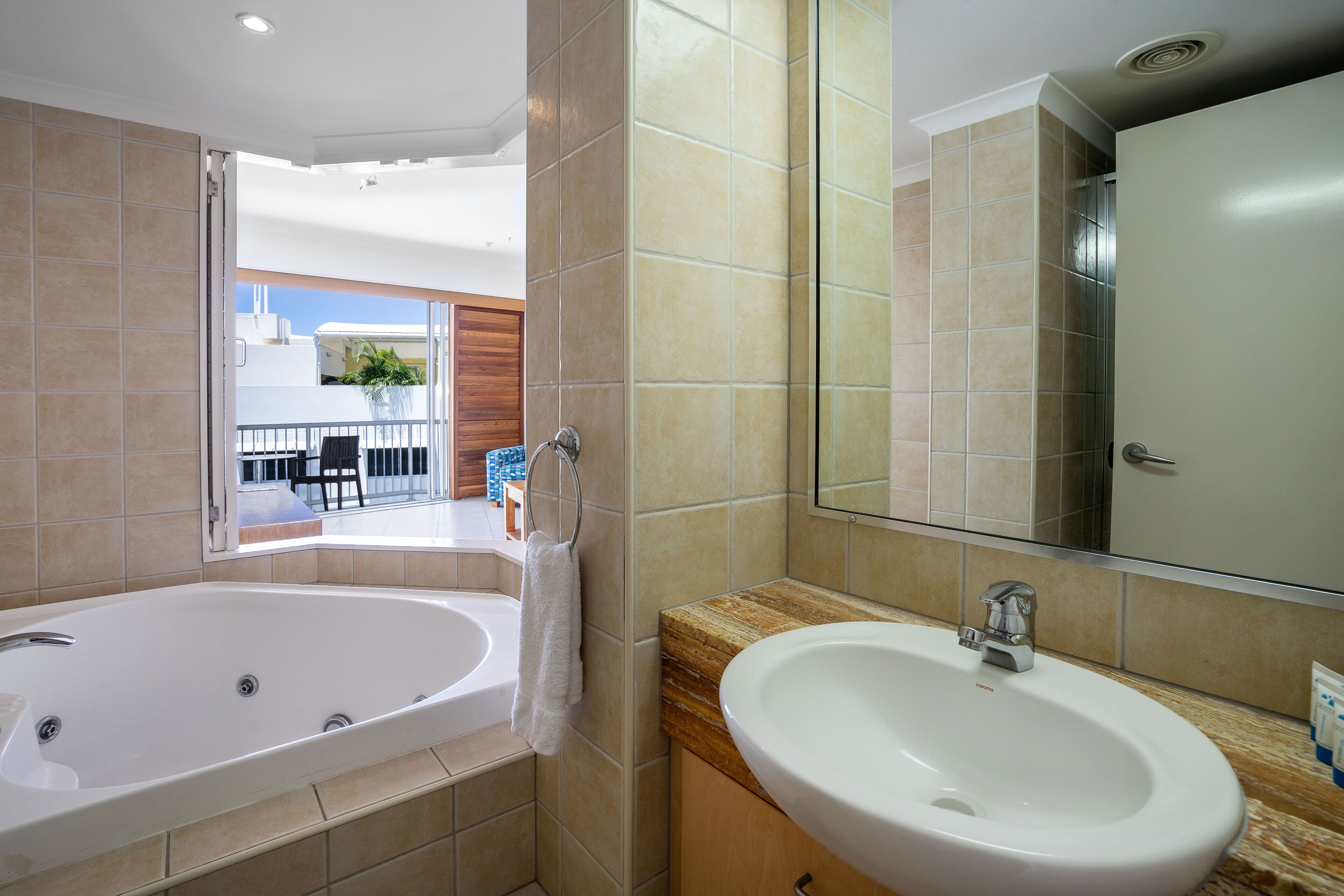 A modern bathroom with a large bathtub, a sink, and a mirror.