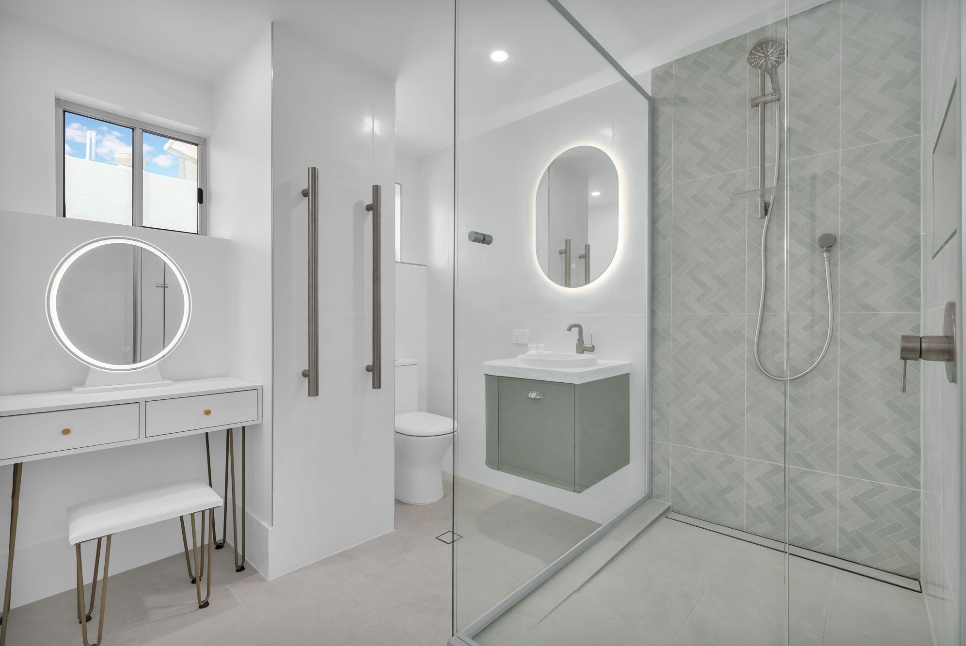 A modern bathroom with a vanity, mirror, toilet, and shower.