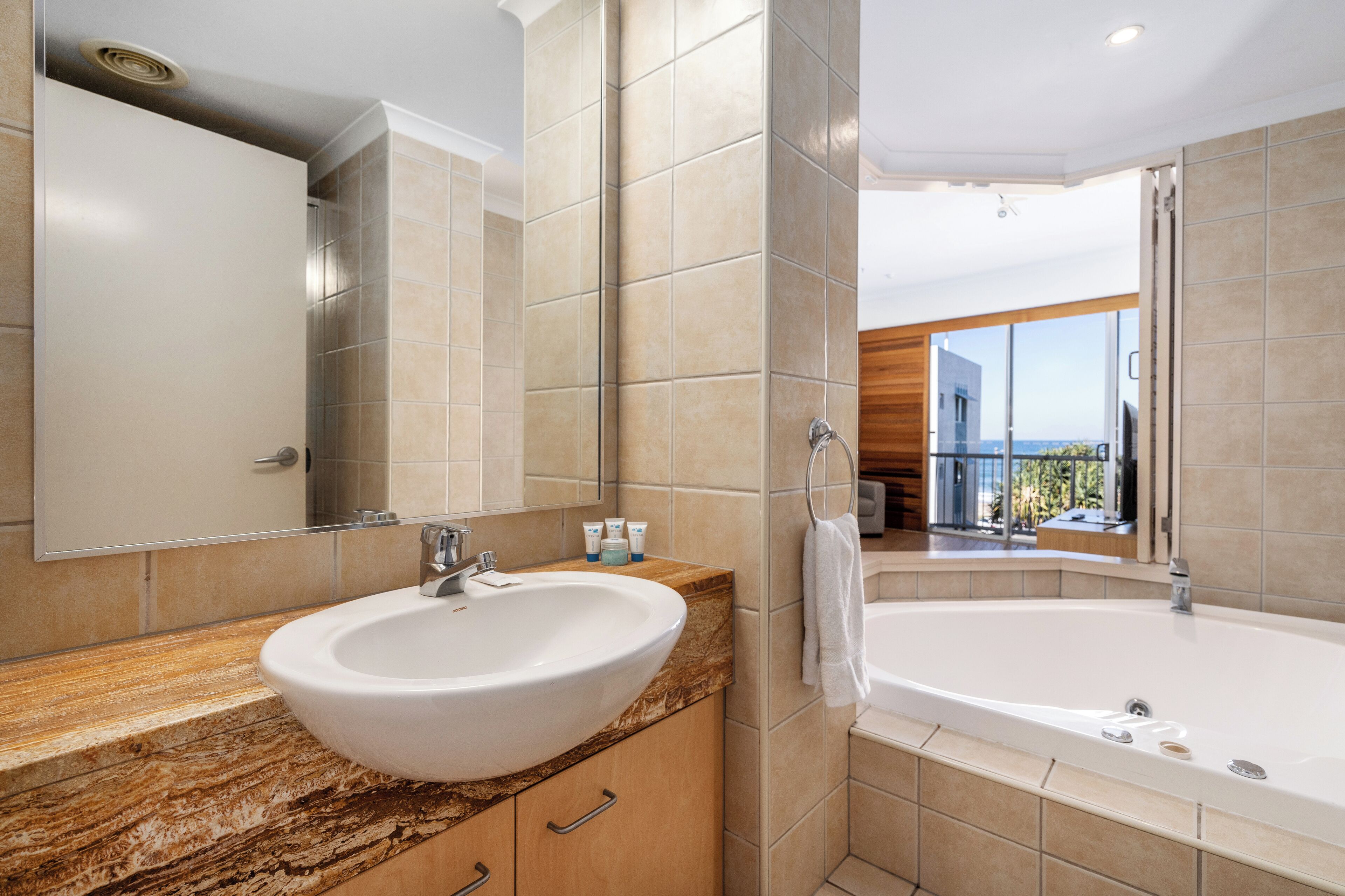 Ein modernes Badezimmer mit einem großen Waschbecken, einer Badewanne und einem großen Spiegel.
