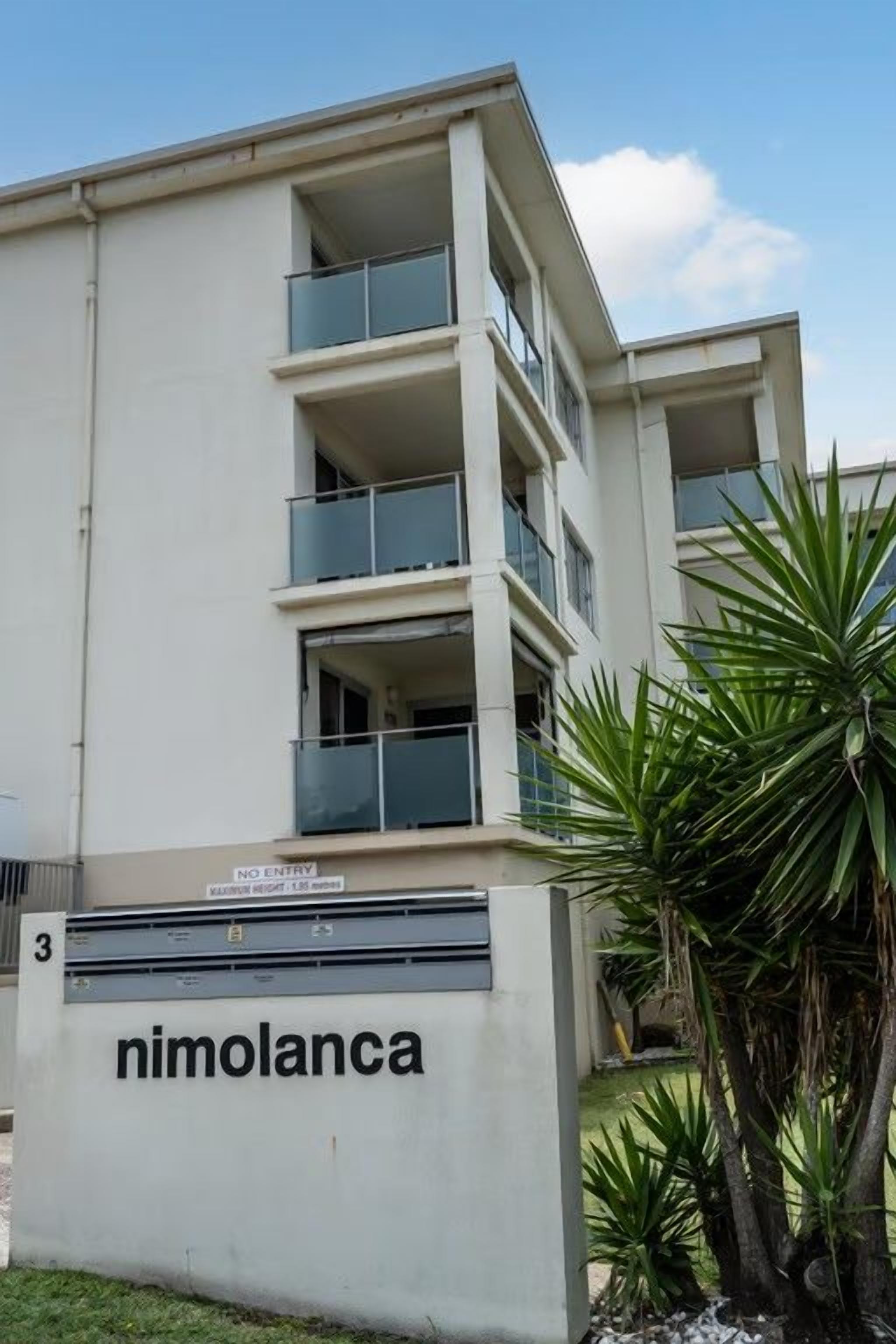A modern building with a sign reading 'nimolanca' and a 'NO ENTRY' sign above the entrance.