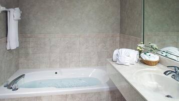 A modern bathroom with a bathtub, a sink, and a mirror.