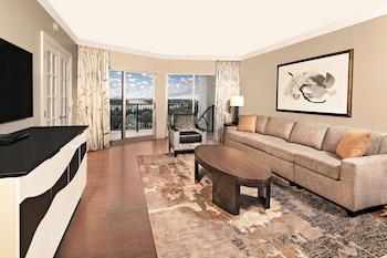 A lobby with a sofa, two armchairs, a coffee table, and three wall-mounted lamps. at Hilton Grand Vacations Club Parc Soleil Orlando