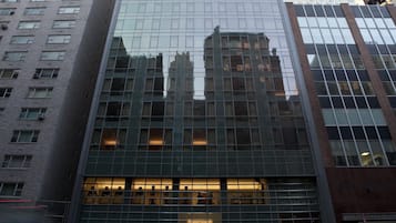 A modern high-rise building with a glass facade and a prominent entrance.