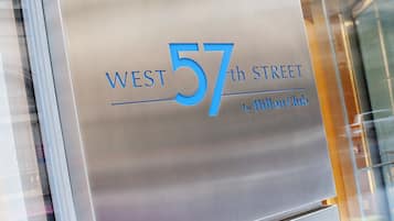 A metallic sign with "WEST 57th STREET by Hilton Club" indicating the hotel's location.