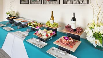 Una mesa de buffet con diversos alimentos y una botella de vino.