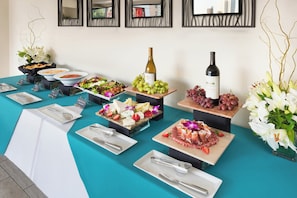 A buffet table with various food items and a bottle of wine. - Hotel Indigo San Diego-Gaslamp Quarter by IHG (San Diego)