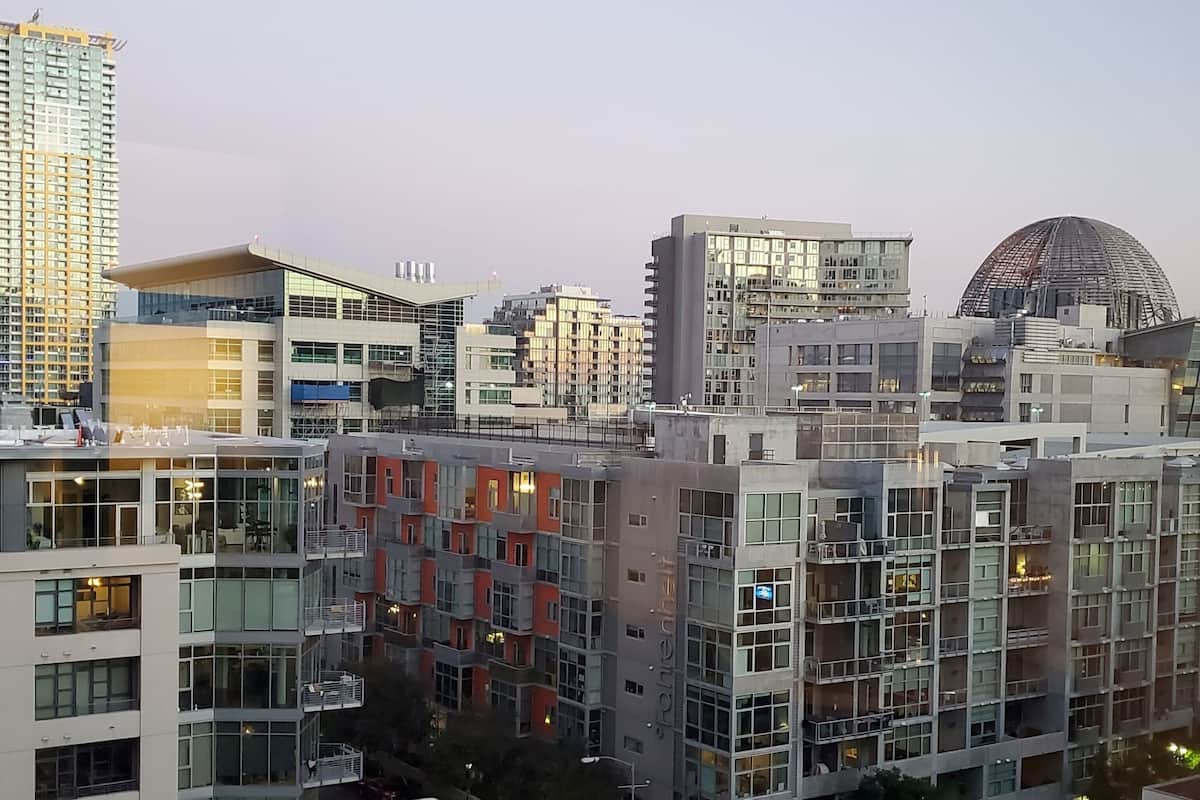 Un immeuble moderne de grande hauteur, doté de nombreux balcons et d’une façade en verre.