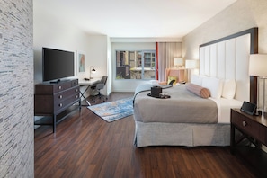 A hotel room with a bed, a desk, a television, and a view of the outside. - Hotel Indigo San Diego-Gaslamp Quarter by IHG (San Diego)