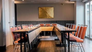 A conference room with a long table, multiple chairs, and a decorative wall piece.