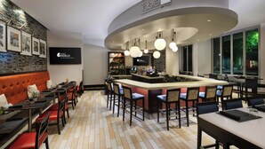 A modern bar area with a curved ceiling, bar stools, and a counter with a minibar.