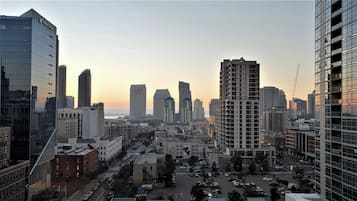 Un paisaje urbano con rascacielos, cielo despejado y vistas al atardecer.