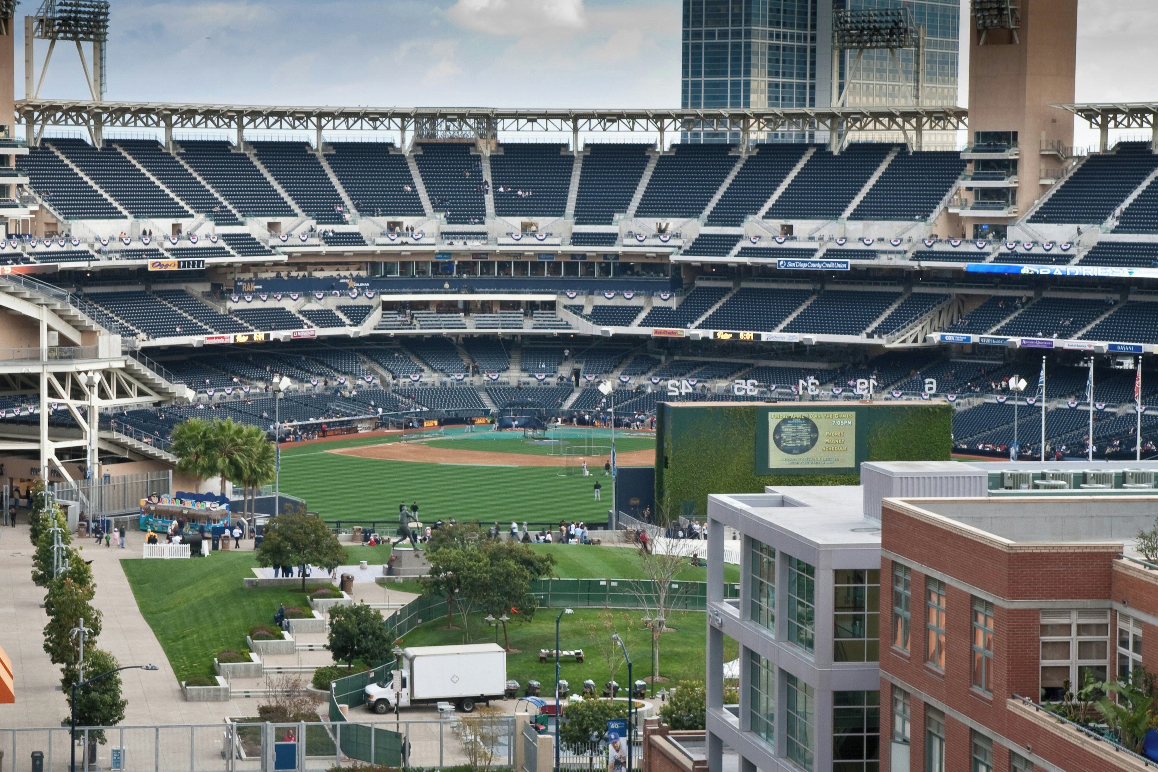 A large stadium with multiple tiers of seating, a baseball field, and surrounding buildings.