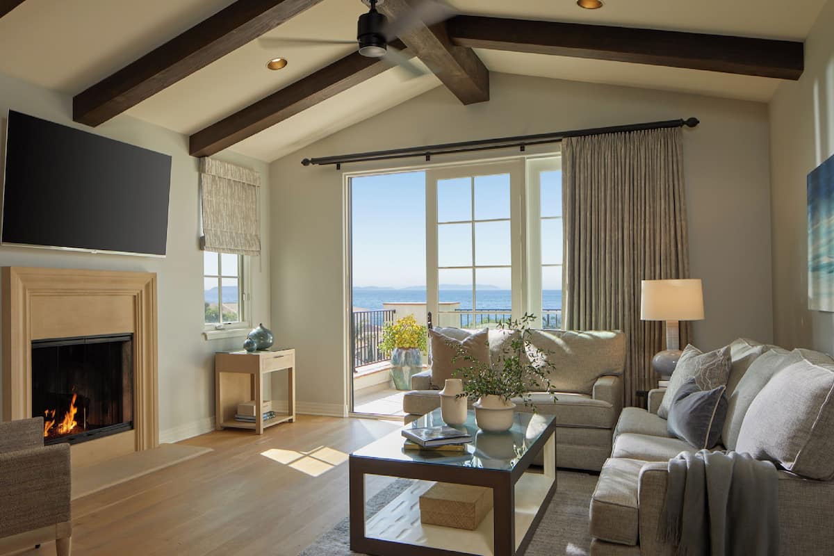A spacious living room with a fireplace, a large flat-screen TV, a sofa, and a coffee table.