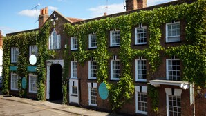 A traditional brick building with ivy-covered walls and multiple windows. - The Talbot Inn (Woking)