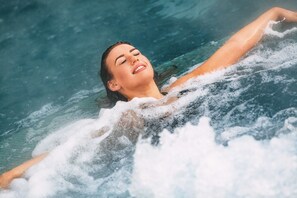 Una piscina cubierta, una piscina al aire libre, tumbonas