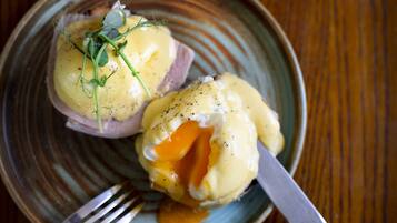 A plate with two poached eggs topped with hollandaise sauce and garnished with herbs.