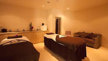 Relax in this serene space with a massage table, a comfortable bed, and a wicker sofa.