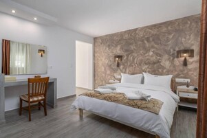 Quarto de hotel moderno com uma cama grande, uma escrivaninha e uma cadeira.