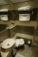 Egy fürdőszoba, amelyben mosdókagyló, WC és törölközőtartó található.