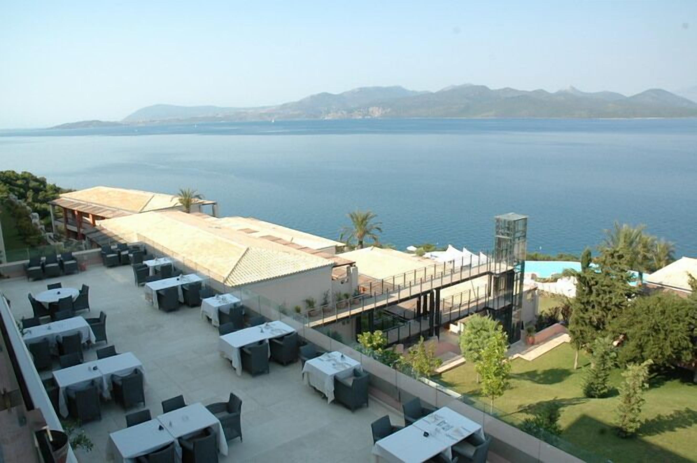 A terrace with outdoor seating and a view of the sea.