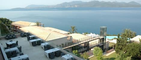 A terrace with outdoor seating and a view of the sea.
