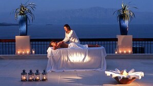 A massage therapy session on a balcony overlooking a body of water, with candles and lanterns for ambiance. - Ionian Blue Bungalows And Spa Resort (Lefkada)