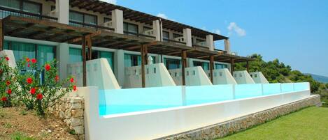Un edificio moderno con varios balcones y una zona de piscina.
