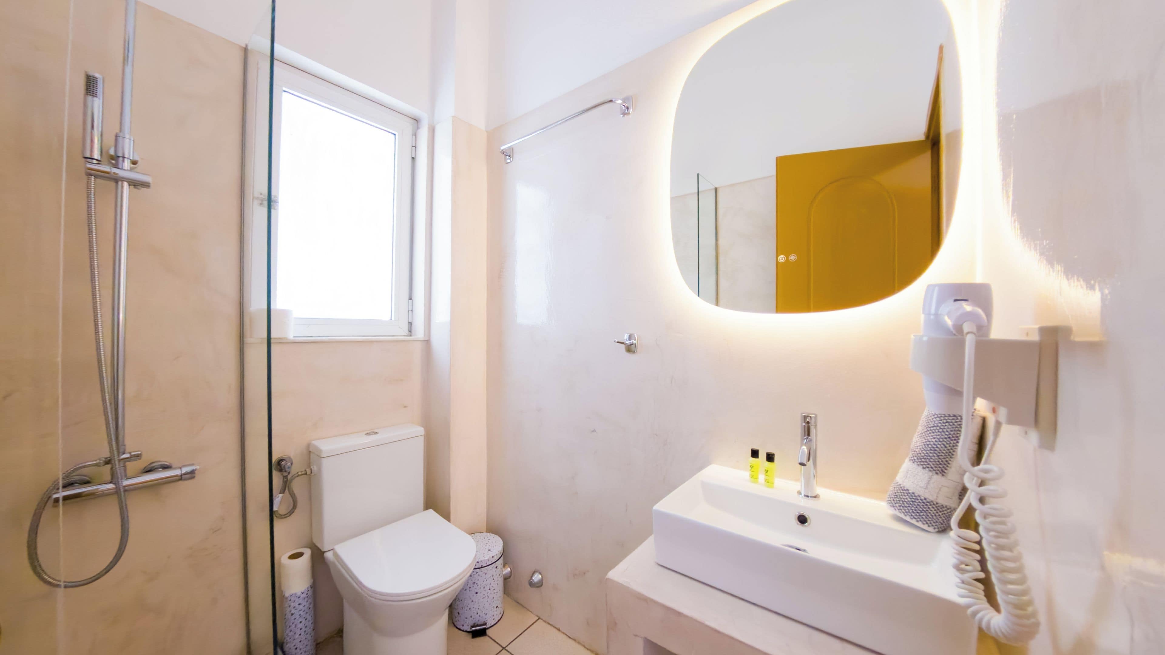 Un baño moderno con inodoro, lavabo y ducha.