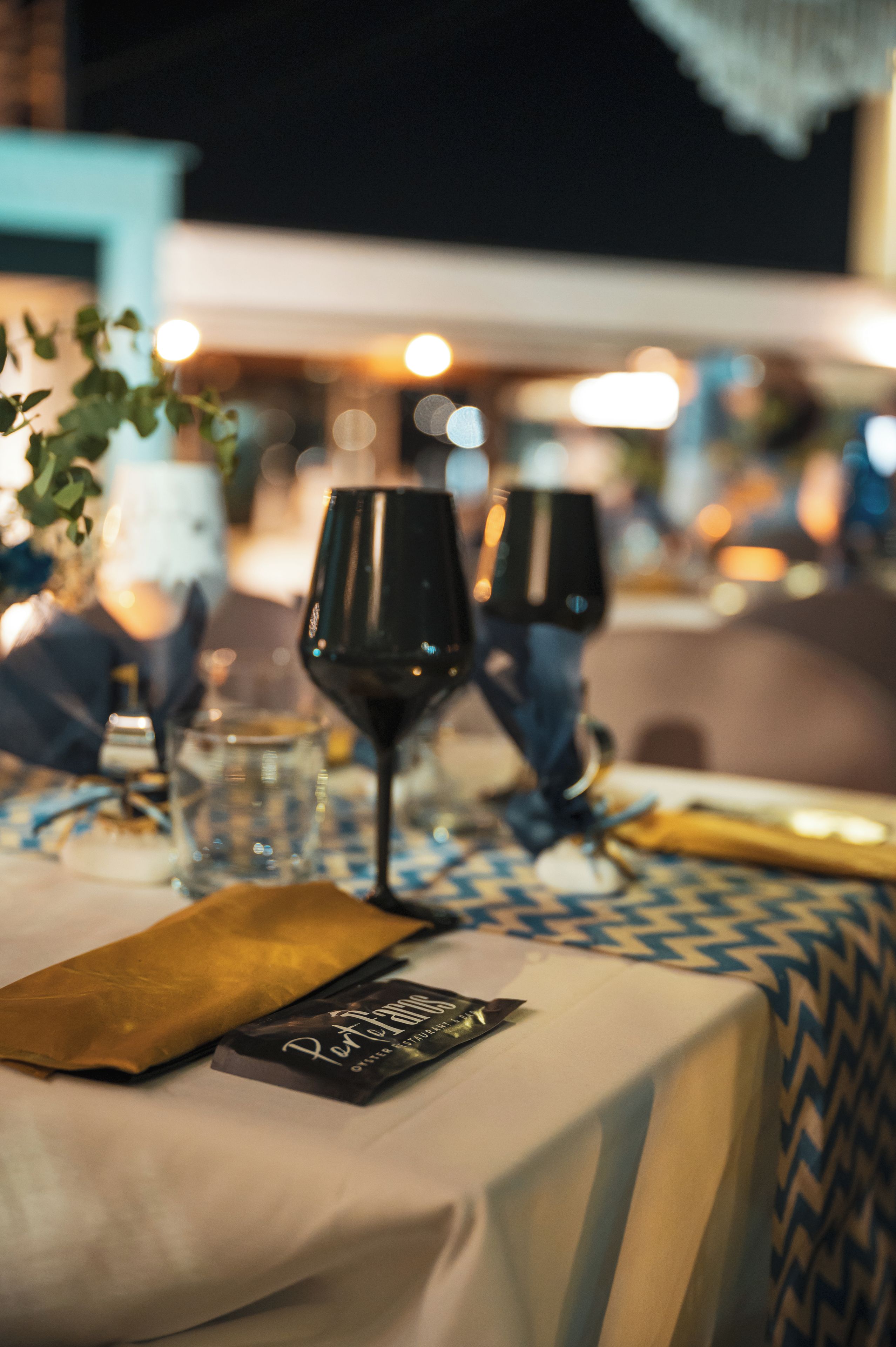 A table set for two with a bottle of wine, a glass, and a menu.