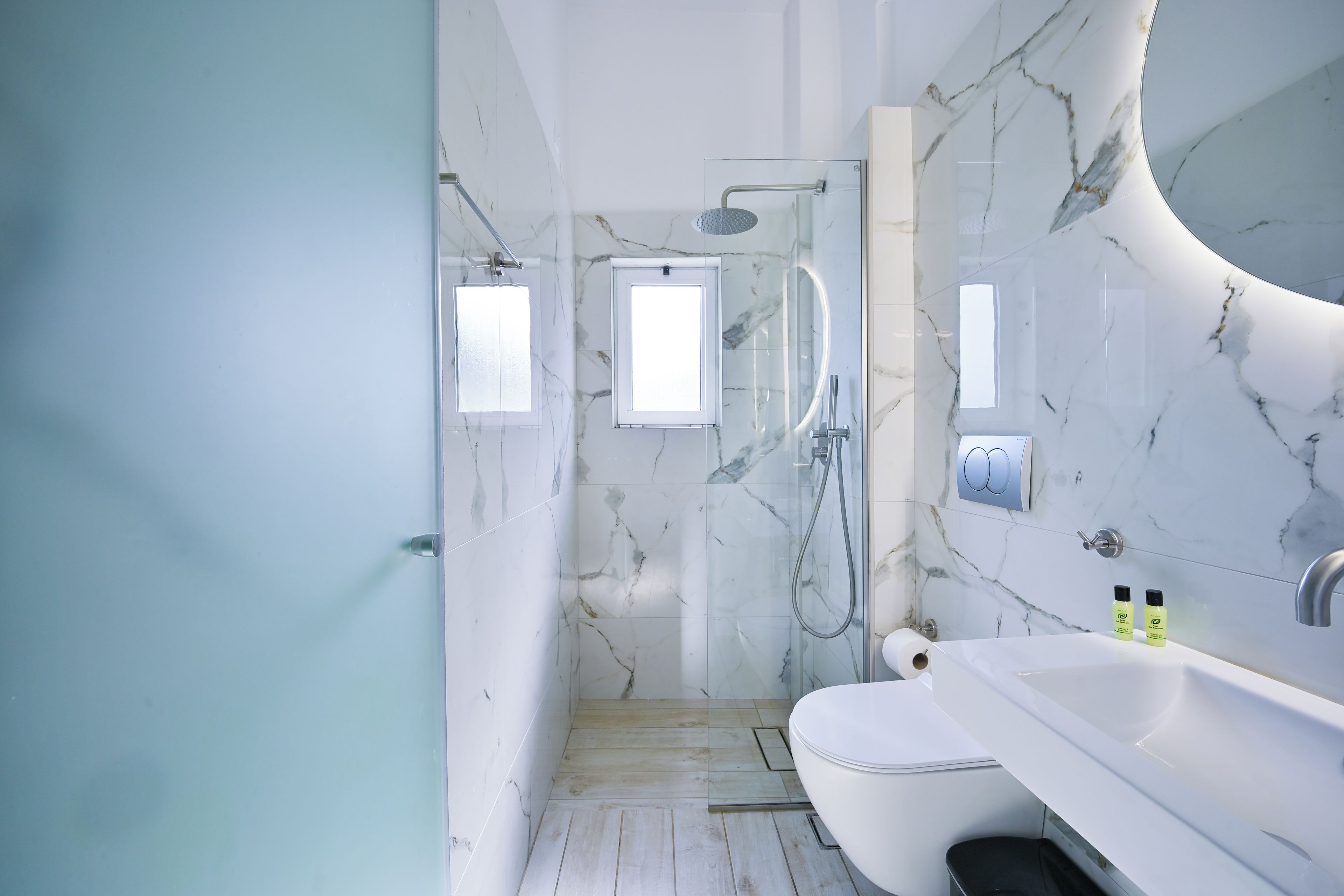 Une salle de bain moderne équipée d’une douche, de toilettes et d’un lavabo.