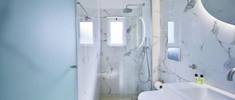 Une salle de bain moderne équipée d’une douche, de toilettes et d’un lavabo.