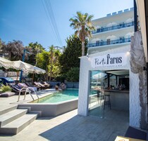 Zona de piscina con sillones de descanso y un bar llamado Porto Faros.