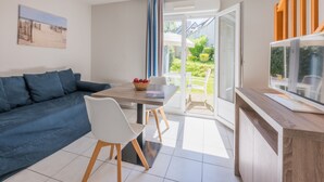 Un salon moderne avec un canapé, une table à manger et un téléviseur.