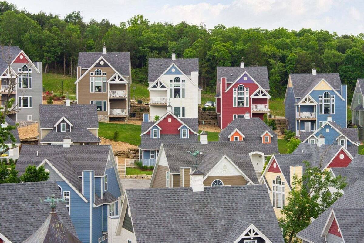 A residential area with houses featuring gabled roofs and various colors.