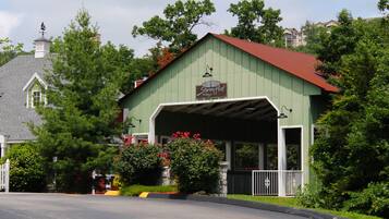 A green building with a red roof, a sign reading "Stormy Point Village Inn," and a covered porch.