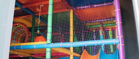 An indoor play area with a colorful ball pit and slides.