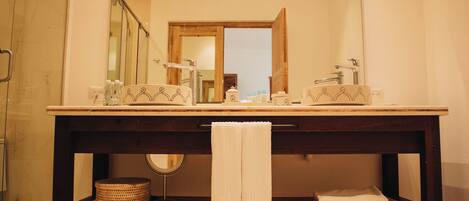 A bathroom with a double sink, wooden vanity, and a large mirror.