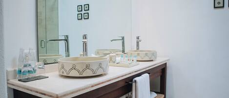 Un baño con dos lavamanos, un espejo grande y un perchero para toallas.
