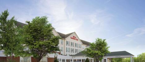 A Hilton Garden Inn with a covered entrance, a parking lot, and surrounding greenery.