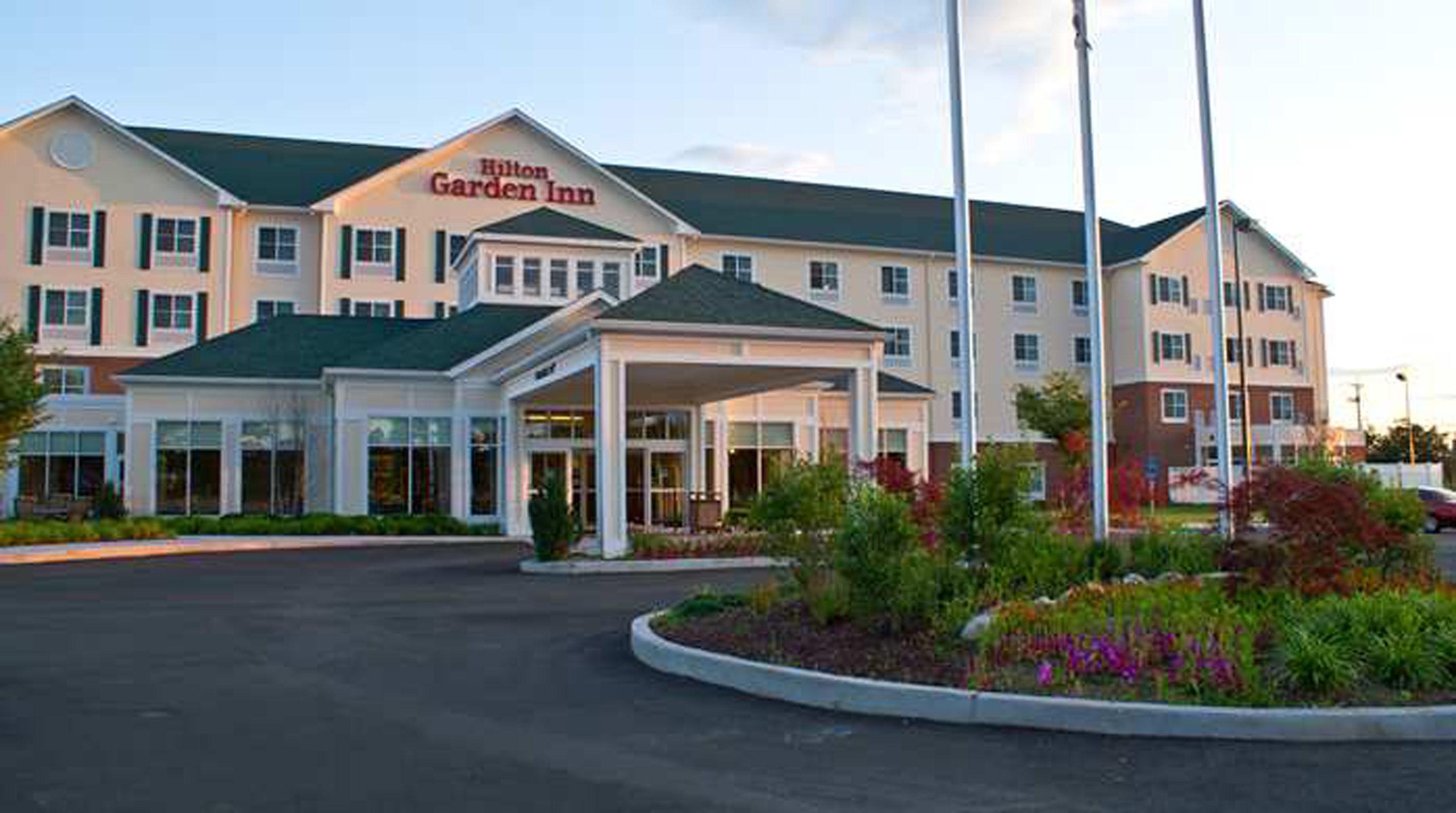 A Hilton Garden Inn with a covered entrance and a landscaped garden area.
