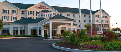 A Hilton Garden Inn with a covered entrance and a landscaped garden area.