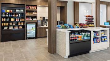 A self-service beverage and snack station with refrigerated drinks, a coffee machine, and various snack options.