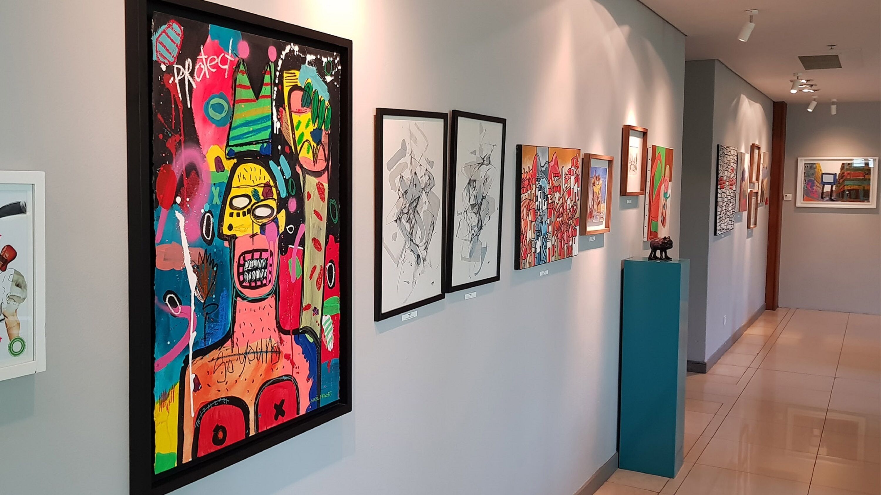 Una galleria d'arte con diverse opere d'arte incorniciate esposte.