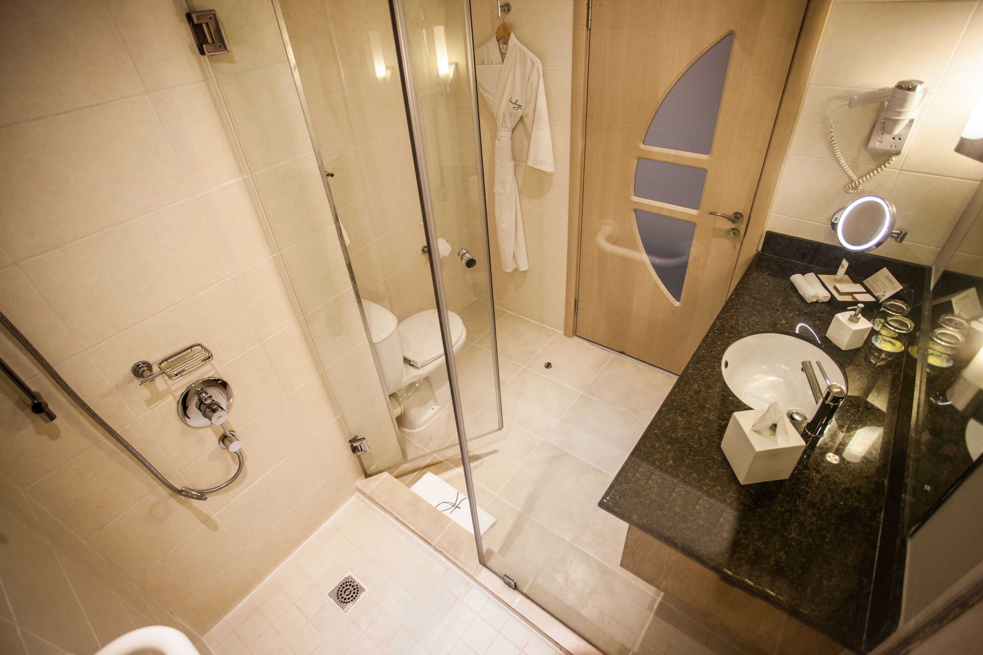 A modern bathroom with a glass-enclosed shower, a vanity with a sink, and a mirror.