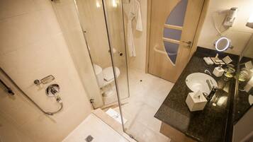 A modern bathroom with a glass-enclosed shower, a vanity with a sink, and a mirror.