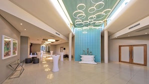 A spacious lobby with a high ceiling, modern lighting, and a central decorative column. - Hennessy Park Hotel (Ebene)